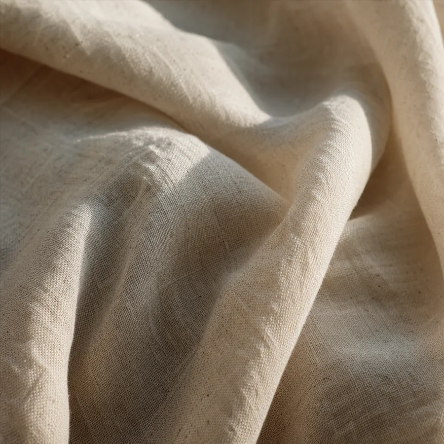 Undyed linen fabric in soft folds under raking daylight.